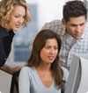 three business people looking at a monitor