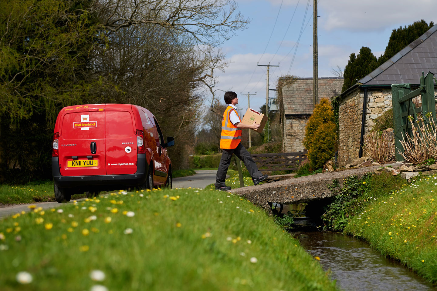 Postwoman delivering parcels in a village